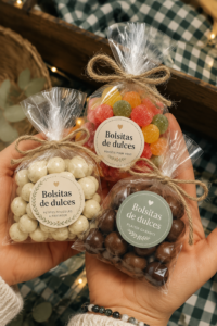 Sachets de douceurs colorés disposés sur une table festive, prêts à être offerts.