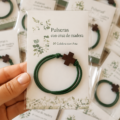 Bracelets en bois à croix présentés sur un fond coloré